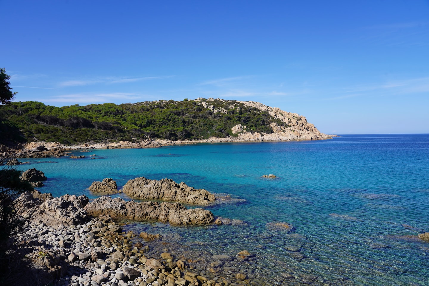 Rocky coastline with turquoise water and lush green cliffs.